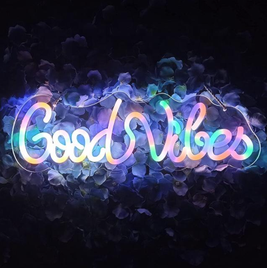 Kleurrijke neonletters vormen de tekst "Good Vibes" op een donkere achtergrond.